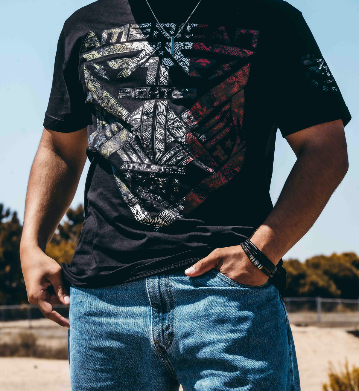 Person wearing a black graphic t-shirt and blue jeans outdoors