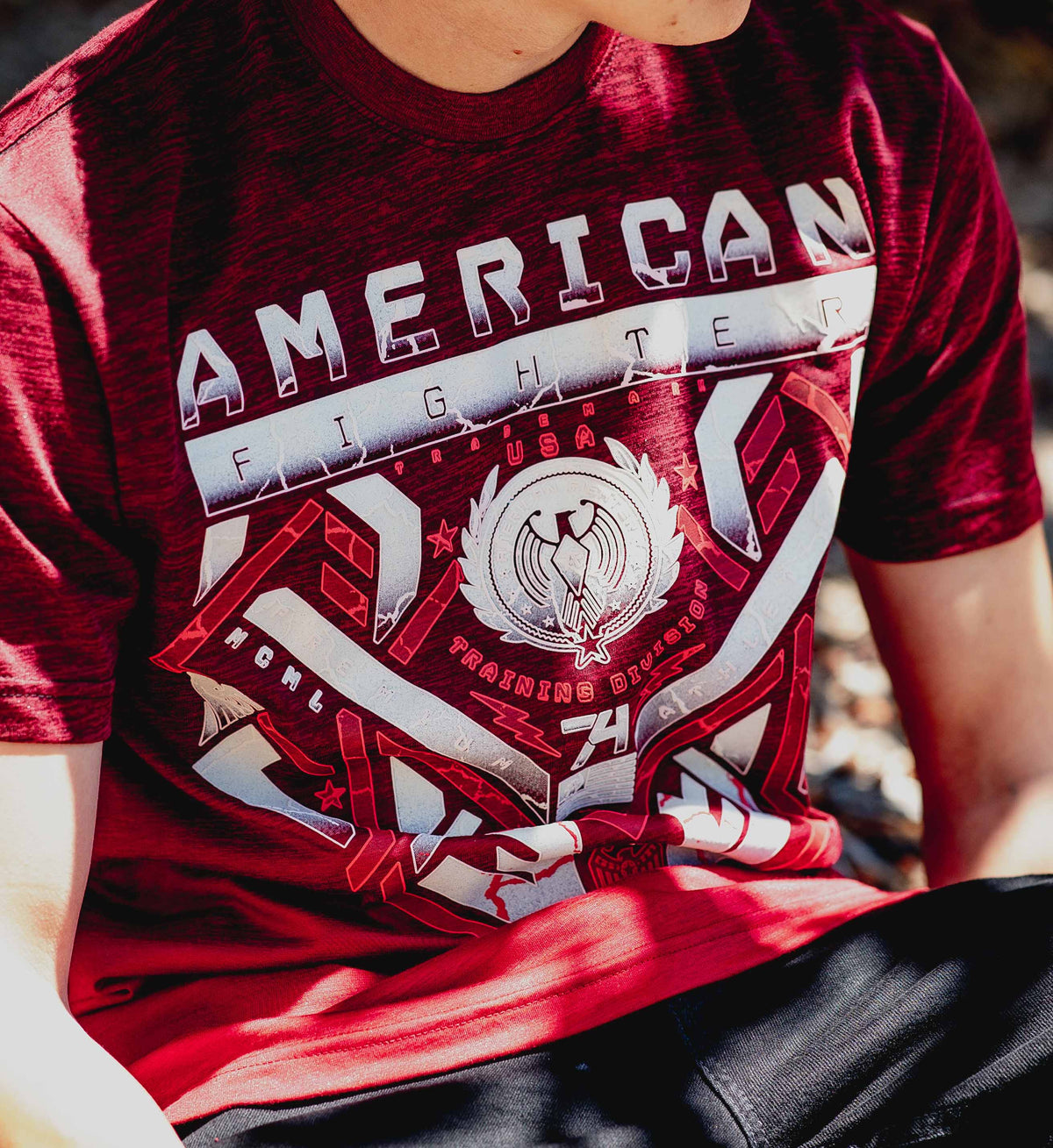 Red t-shirt with 'American Fighter' graphic design worn by a person.