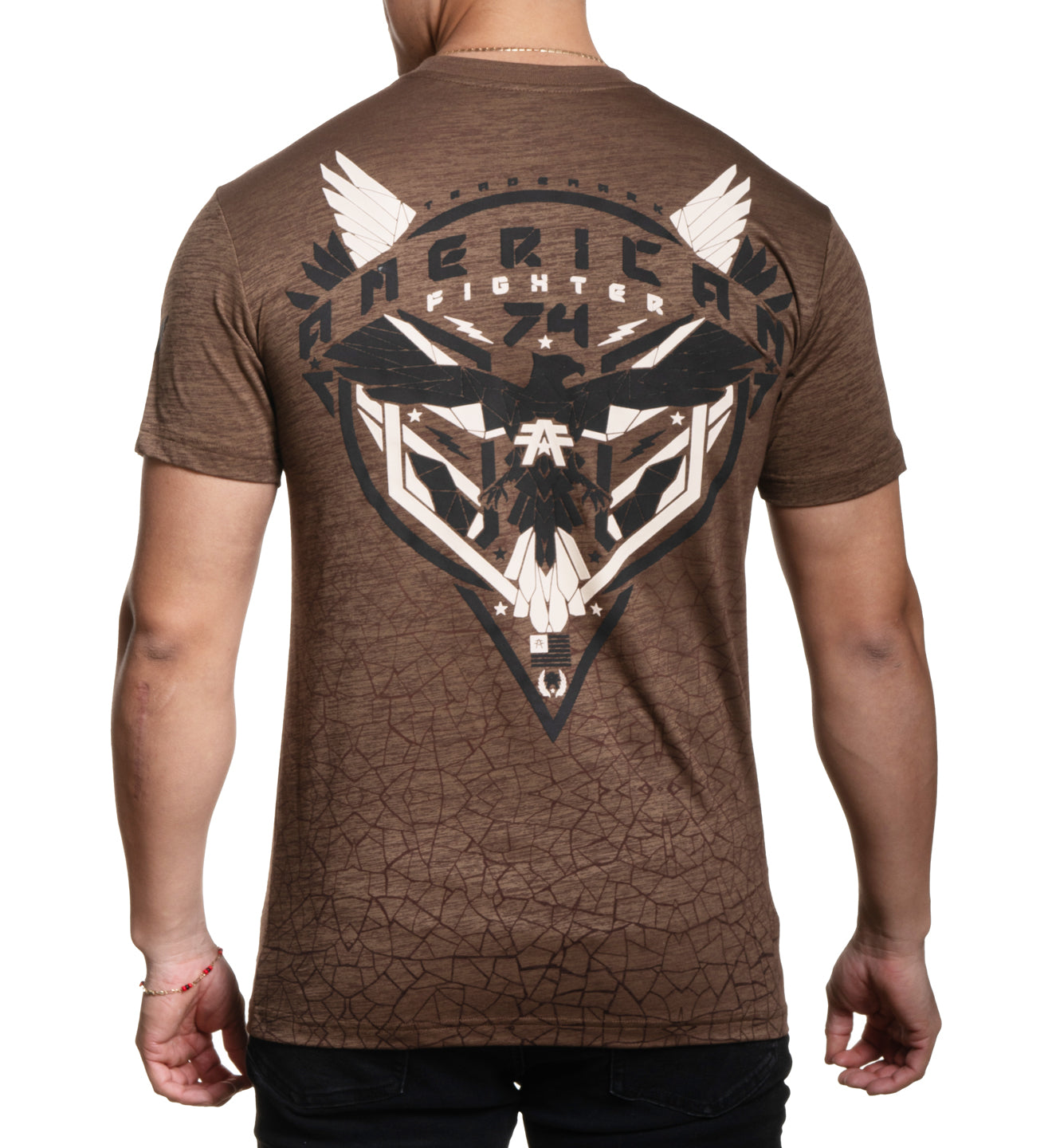 A male model wearing a brown short-sleeved t-shirt with a graphic print of a bull and the word 'AMERICAN' on it.