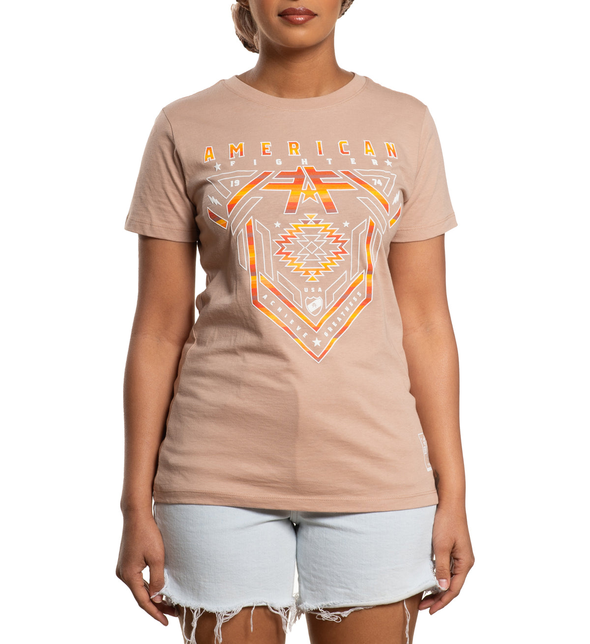 A woman wearing a beige t-shirt with 'AMERICAN' and a geometric design in orange and yellow on the front.